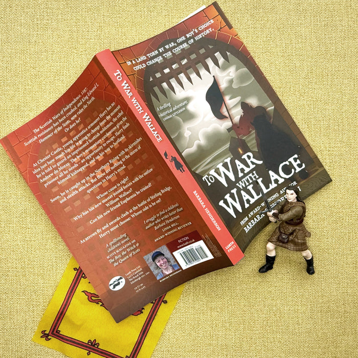 Book titled 'To War with Wallace' on a textured surface with a small figurine. - Image