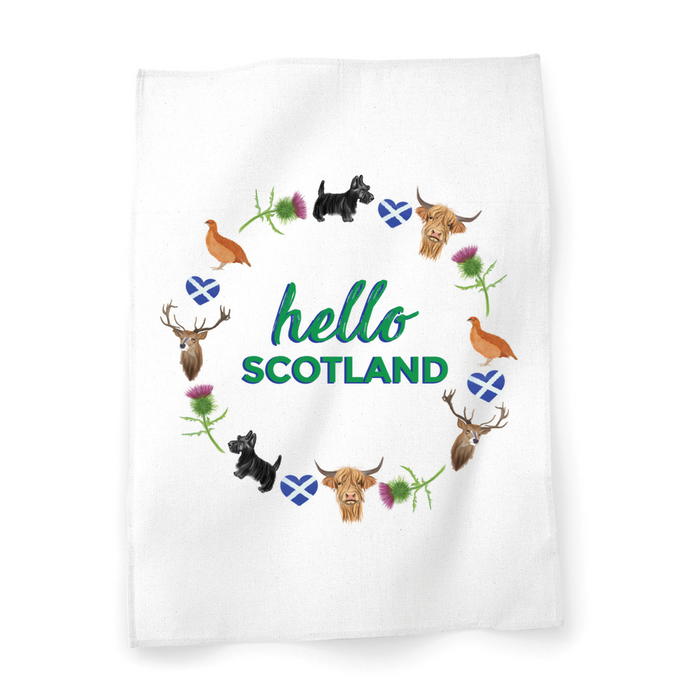 A beautiful designed white cotton tea towel with the words 'Hello Scotland' in green, adorned with illustrations of elements of Scottish culture and scenery.