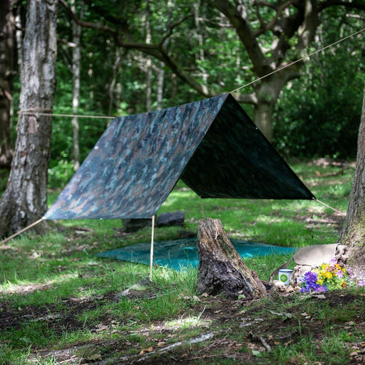 outdoor woodland scene wit the den kit made up between two trees 