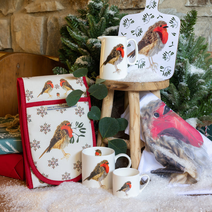 image of Christmas robin oven gloves sitting on table with other items from the collection 