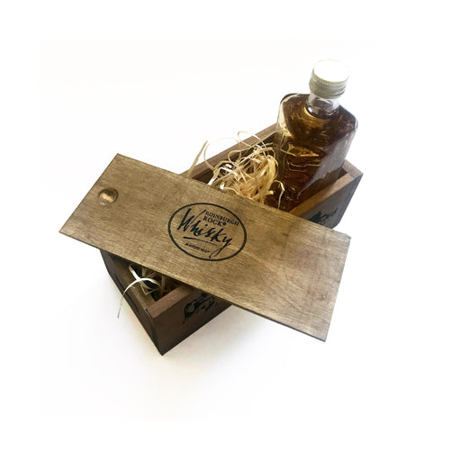 bottle shown upright with wood box lid set on at angle showing contents