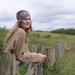 fairisle thick thistle headband shown on model in field at gate in scottish countryside