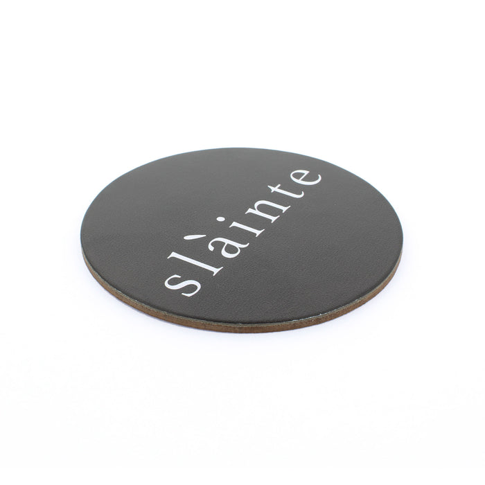 round black leather drinks coaster with word Slàinte written in middle in white letters