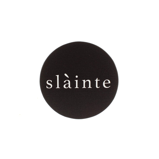 face on view of a round black leather drinks coaster with word Slàinte written in middle in white letters