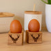 set of 2 wooden eg cups with stag heads motif shown holding boiled eggs