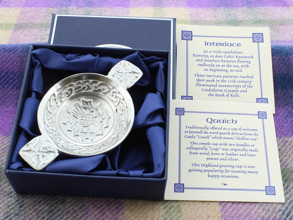 Quaich Mini Thistle shown in open box with explanation cards shown adjacent on blanket background