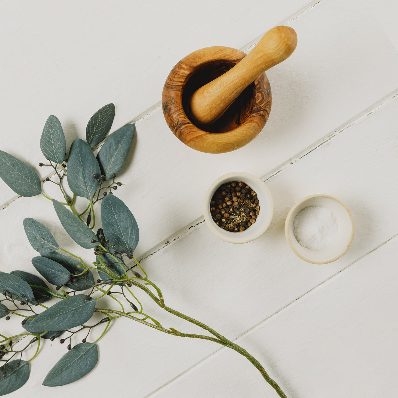 Wooden Pestle & Mortar Set shown next to branch and small bowl of peppercorns and bowl of coarse salt - Image