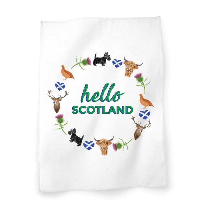White cotton teatowel with written text that reads 'hello Scotland', surrounded by a circular motif featuring Scottish Icons. 